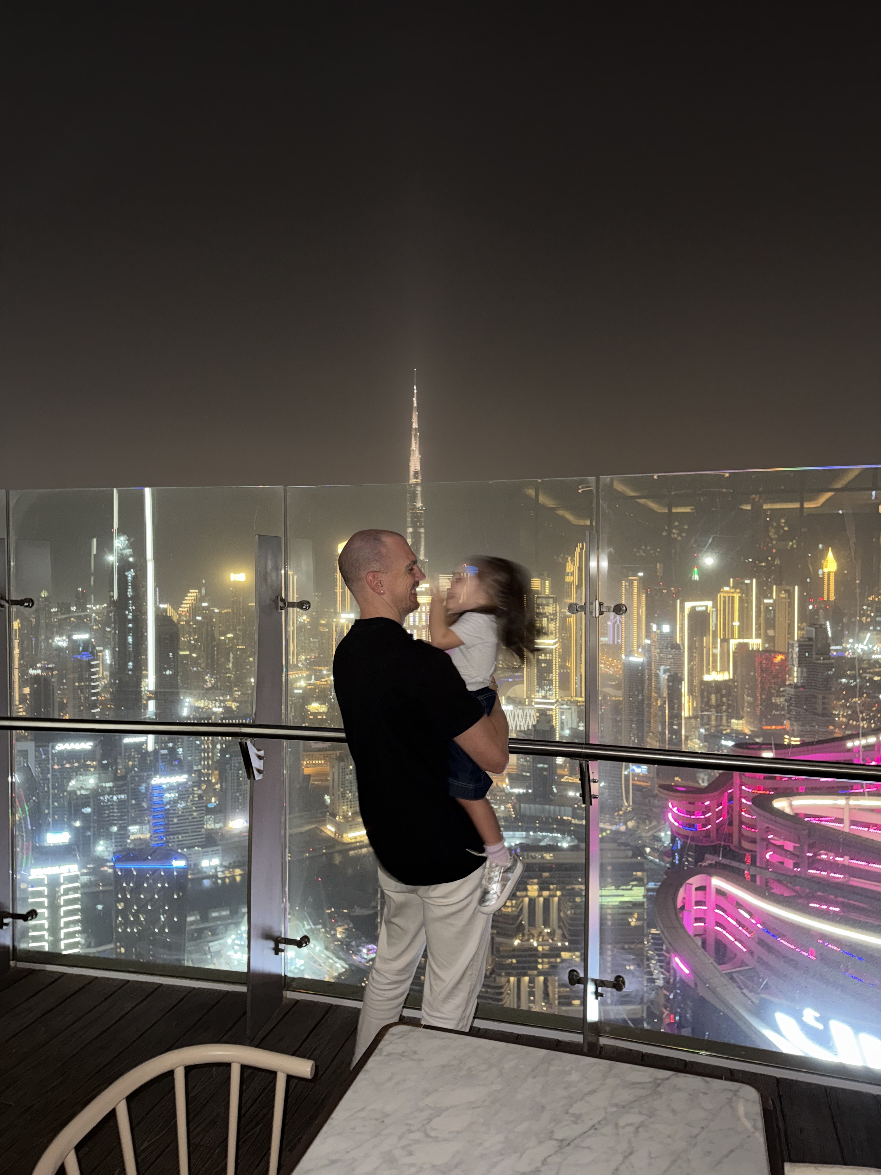 Alessandro Picchianti holding his daughter on a terrace above Downtown Dubai at night
