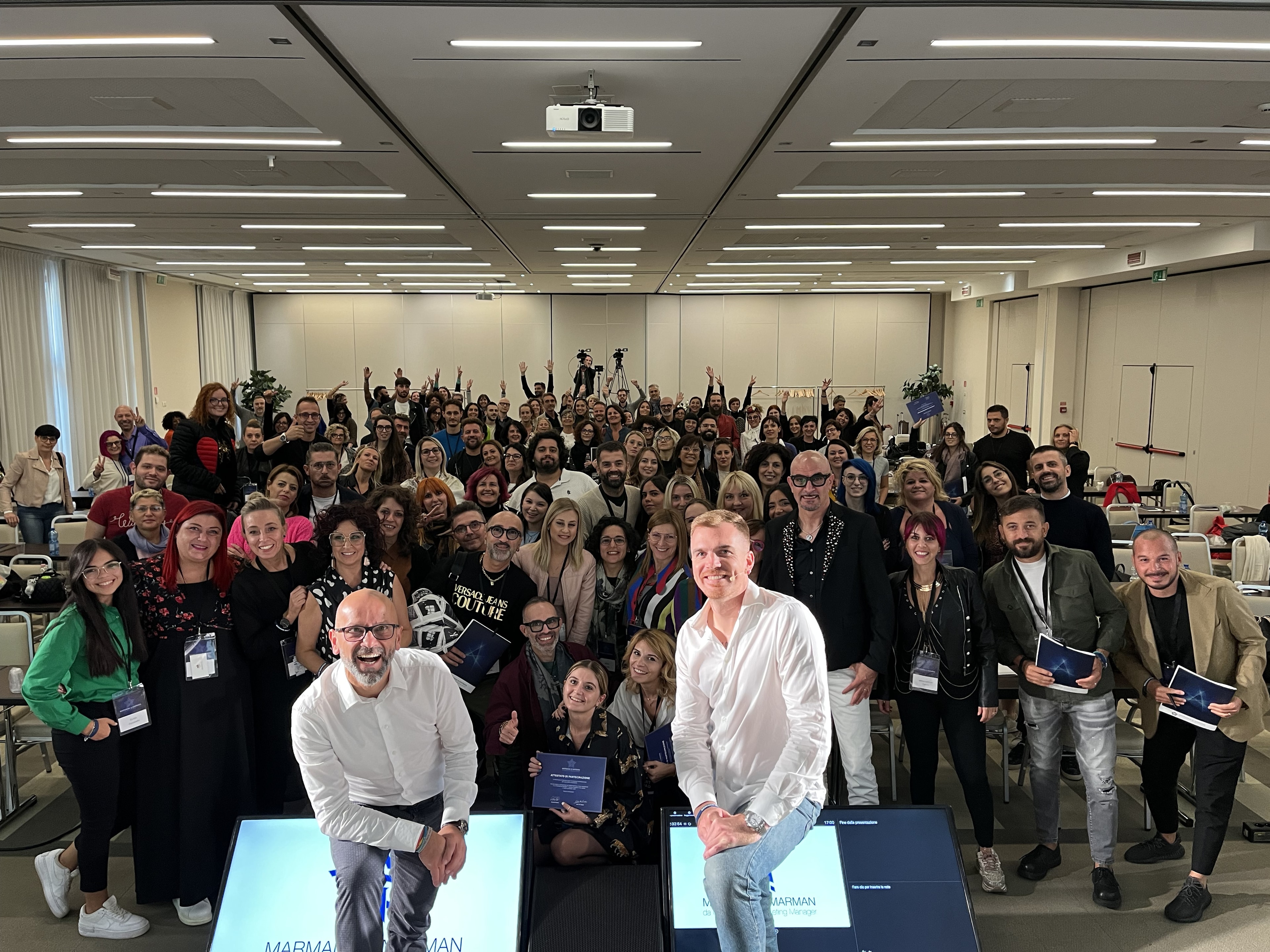 Alessandro Picchianti and his business partner with a cheering room of training attendees